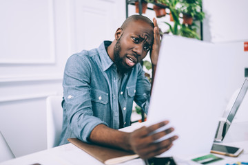 Worried black guy reading papers