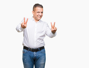 Middle age arab elegant man over isolated background smiling looking to the camera showing fingers...