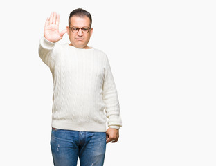 Fototapeta premium Middle age arab man wearing glasses over isolated background doing stop sing with palm of the hand. Warning expression with negative and serious gesture on the face.