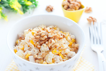 Salad with corn, chicken and pineapples in a white bowl, horizontal