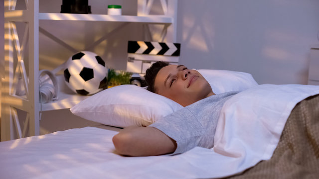 Happy smiling handsome teenager waking up early in morning, promising student - Powered by Adobe