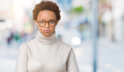 Obraz premium Young beautiful african american woman wearing glasses over isolated background skeptic and nervous, frowning upset because of problem. Negative person.