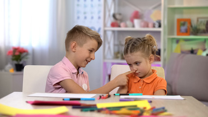 Playful brother touching sisters nose, children communication, apologizing