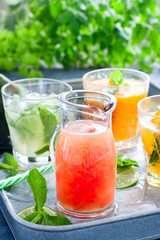 Cold grapefruit juice on a background of summer cold citrus drinks: mojito, lemonade, orange juice, tangerine juice, selective focus