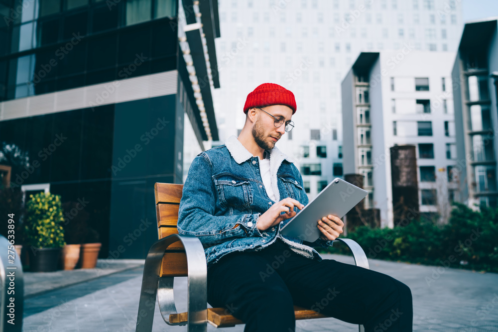 Poster handsome millennial man checking email information on digital tablet connected to 4g wireless for ne