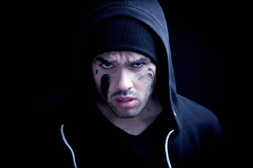 Portrait of aggressive male robber as symbol of aggression and gangsterism.