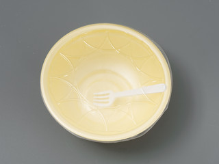 disposable dishes for fast food. bowl with lid and fork. on gray background