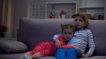 Cute brother and sister hugging, watching movie, gadget leisure, television