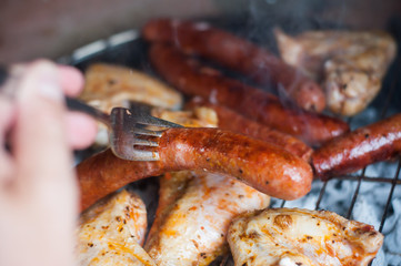 closeup of sausages and chicken  on the barbecue