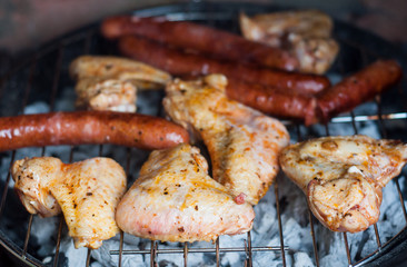 closeup of sausages and chicken  on the barbecue