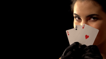 Flirty woman hiding behind three of aces, winning poker combination, fortune