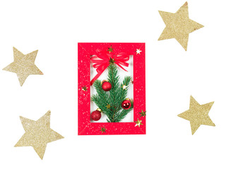 New Year's composition. In a red frame in the center the fir-tree branch decorated with Christmas toys. big gold stars at the edges of a white background. It is isolated