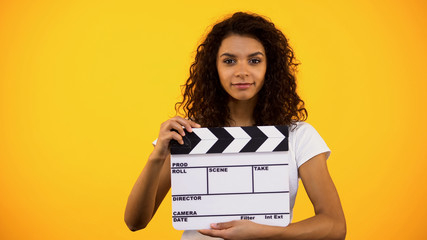 Attractive black woman holding clapper board, film studio, actor audition, clip