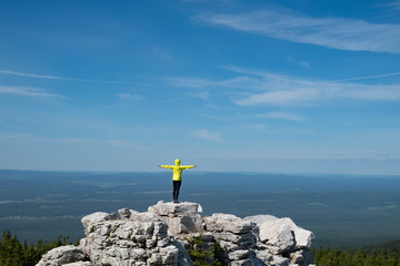 a man in a bright jacket stands on top of a mountain. The scale of the planet. freedom