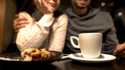 Old friends sitting in cafe, hugging and talking, warm relationship, close up