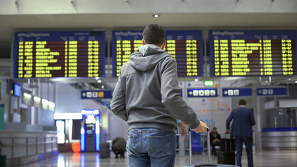 Tourist looking at time table, checking schedule on screen in bus terminal