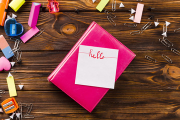 Stationery around notepad with note