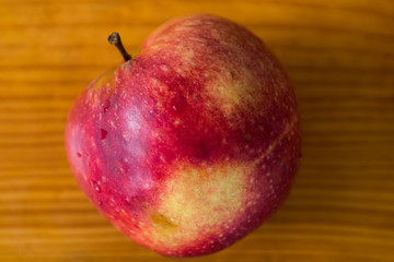 red apple on a wooden gray board, drops of water on the apple, texture, background, close-up, fruit