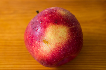 red apple on a wooden gray board, drops of water on the apple, texture, background, close-up, fruit
