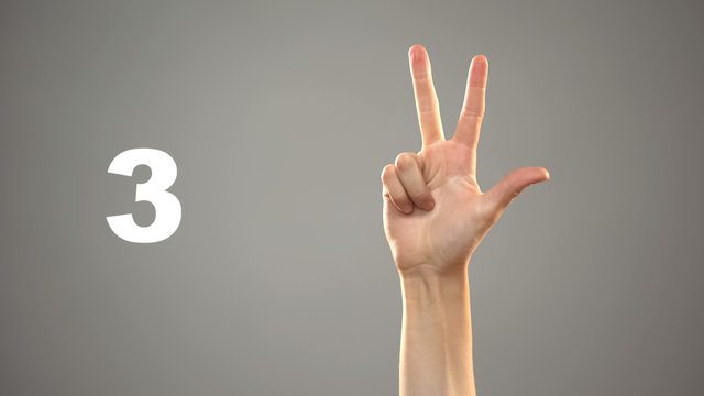 Hand signing 3 in asl, number on background, sign language tutorial for deaf