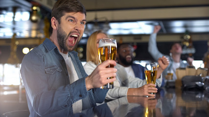 Overemotional caucasian make cheering for favorite team with friends in bar