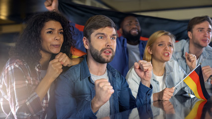 German football fans supporting national team at match, worrying about winning - Powered by Adobe