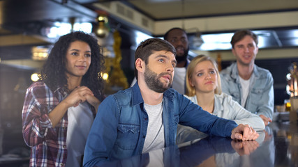 Deeply upset football fans watching game in pub, team losing championship