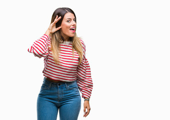 Young beautiful woman casual stripes winter sweater over isolated background smiling with hand over ear listening an hearing to rumor or gossip. Deafness concept.