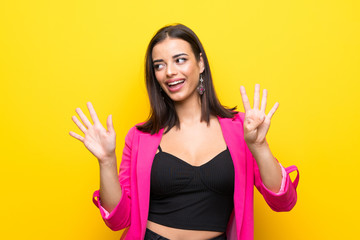 Young woman over isolated yellow background counting nine with fingers