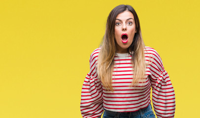 Young beautiful woman casual stripes winter sweater over isolated background afraid and shocked with surprise expression, fear and excited face.