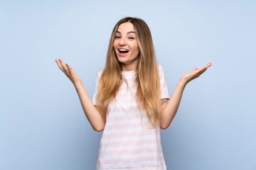 Fototapeta na wymiar Young woman over isolated blue background smiling a lot