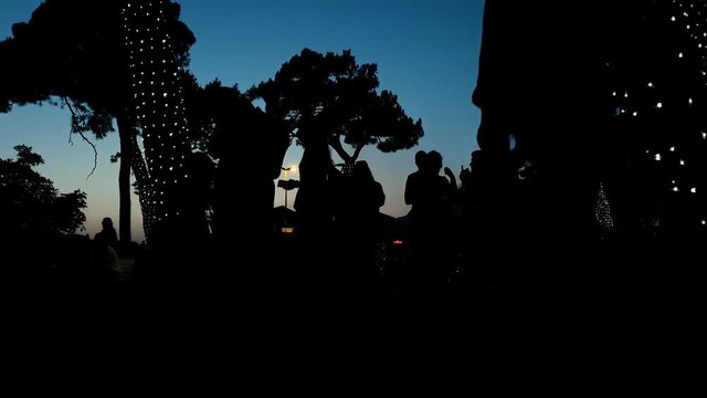 tima lapse of people silhouettes spending summer sunset in urban park