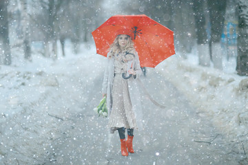 spring snowfall beautiful girl with flowers / concept of international women’s day march, gift for girlfriend, happiness