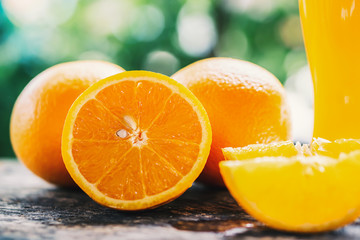 orange sliced and orange juice glasses with green leaf on wooden table 