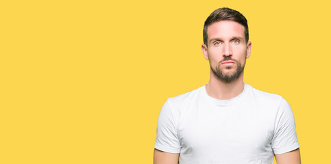 Handsome man wearing casual white t-shirt Relaxed with serious expression on face. Simple and natural looking at the camera.