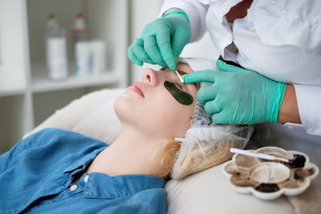Beautician performing henna eyelashes correction