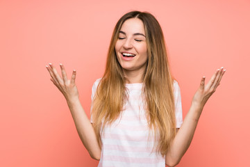 Young woman over isolated pink wall laughing