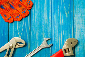 Necessary set of tools for plumbers on a blue wooden background.