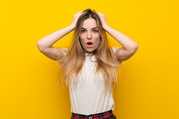 Young woman over isolated yellow wall with surprise facial expression