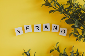 The inscription verano in spanish on the letters of the keyboard on a yellow background with...