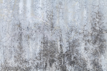 Old gray wall covered with uneven plaster. Texture of vintage shabby silver stone surface, closeup.