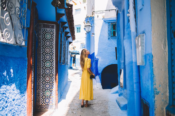 Beautiful girl with amateur camera standing in tourists city - Morocco inspecting oriental mosaic...