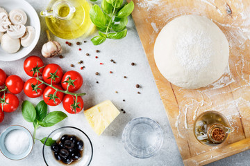 The ingredients for homemade pizza on wooden background.