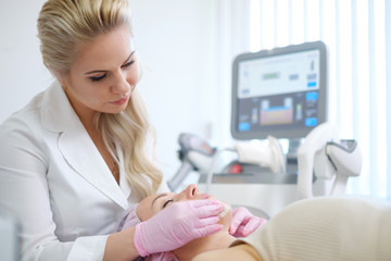 Woman getting treatment with aesthetic dermatology device