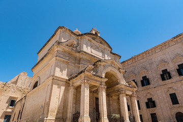 Fototapeta na wymiar Street of Valleta, Malta's capital. Cityscapein Sunny Day. Church in the town.