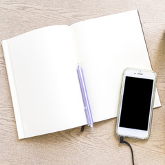 Overhead view of blank paper with pen and cellphone on wooden table