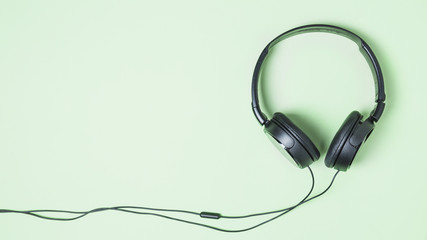 Panoramic view of black headphone on turquoise background