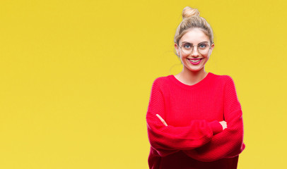 Fototapeta premium Młoda piękna blondynka na sobie czerwony sweter i okulary na białym tle szczęśliwa buźka uśmiecha się ze skrzyżowanymi rękami patrząc w kamerę. Pozytywna osoba.