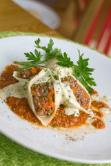 Pasta shell conchiglioni with minced meat filling in sauce close-up in dish. depth of field.