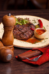 Well-done steak with suace and vagetables. Food photo for restaurant menu.